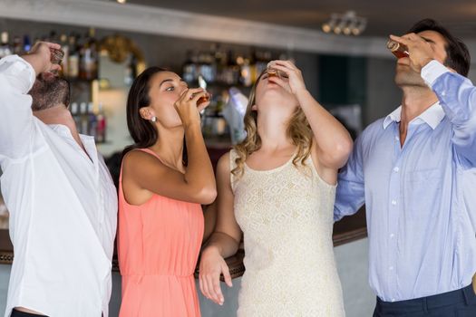 Group of friends having tequila shot