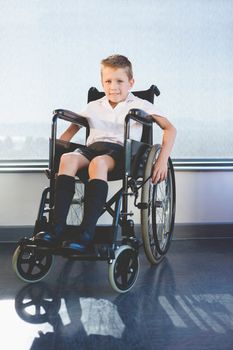 Portrait of schoolkid sitting on wheelchair