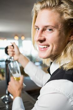 Waiter filling beer from bar pump