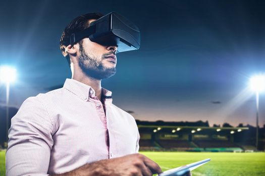 Composite image of man using an oculus and a tablet