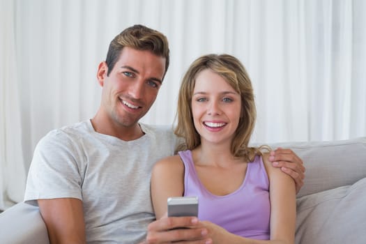 Relaxed couple text messaging on couch