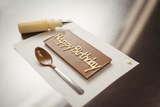 Happy birthday written on chocolate plaque