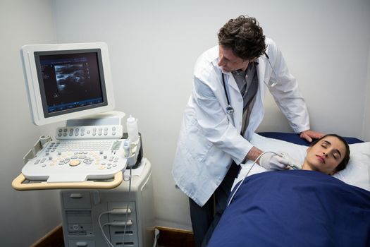 Doctors performing a doppler sonography on patient neck