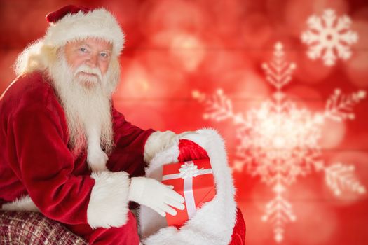 Portrait of santa claus removing gift from sack