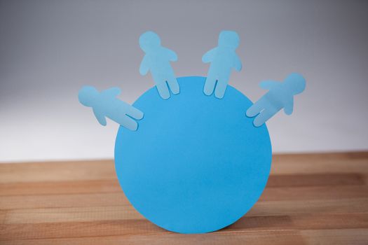 Blue paper cut-out people on the circle
