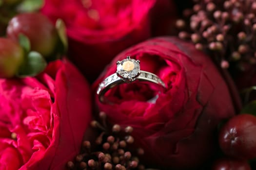 Bridal bouquet made with red roses with wedding rings. Shallow dof