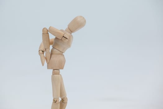 Wooden figurine standing with hands on back