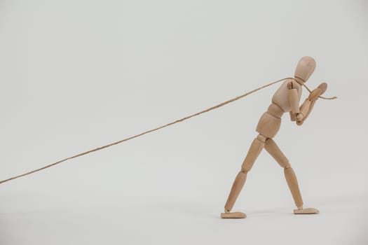 Wooden figurine pulling a rope