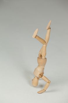 Wooden figurine performing a headstand