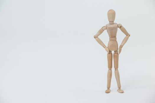 Wooden figurine standing with hands on hips