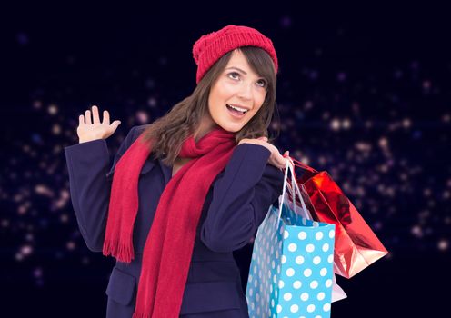 Woman holding shopping bag against dark background