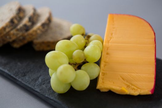 Gouda cheese and grapes on slate plate