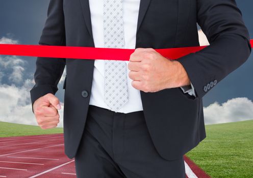 Businessman crossing finish line during race