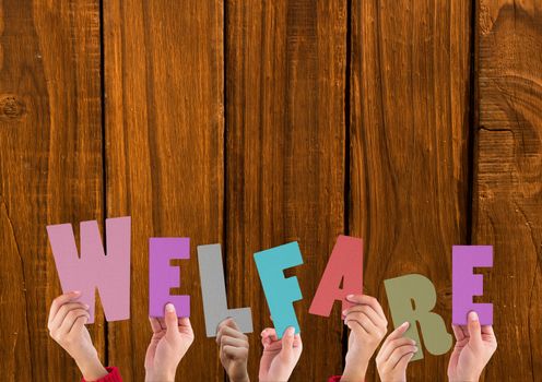 Hands holding word Welfare against wooden background