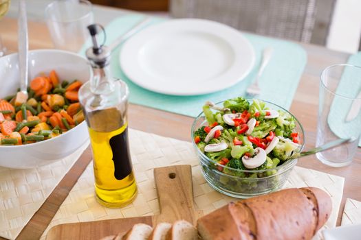 Bowl of salad and olive oil on dinning table