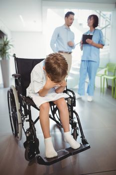 Sad disable boy in wheelchair in corridor