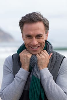 Smiling mature man standing on the beach