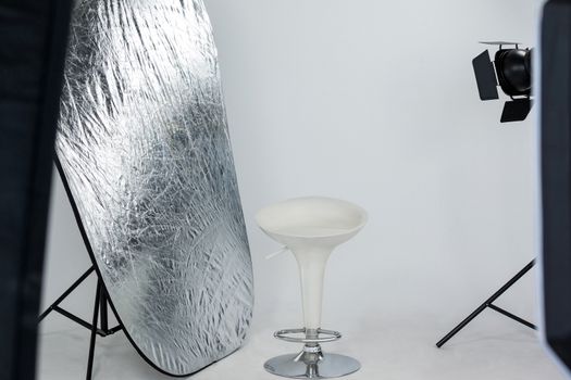 Stool with reflector and studio light in studio