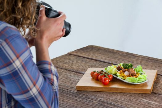 Photographer clicking a picture of food using digital camera in studio