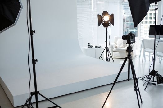 Photo studio with tripod, lighting equipment and digital camera