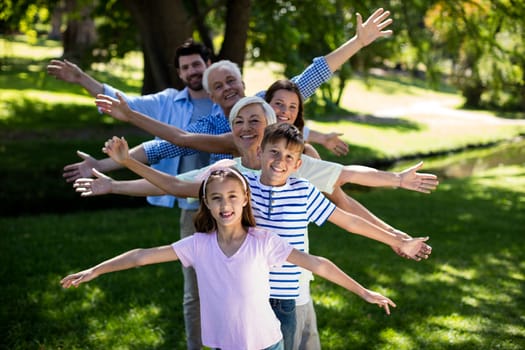 Multi generation family standing in a row with arms outstretched