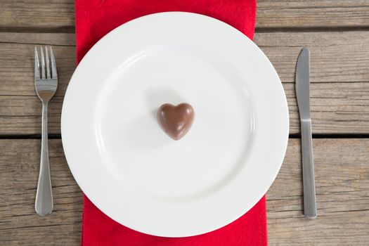 White plate with red heart chocolate in center