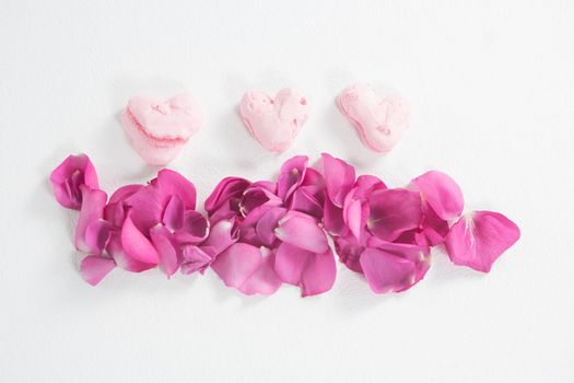 Heart shaped confectionery and pink rose petals