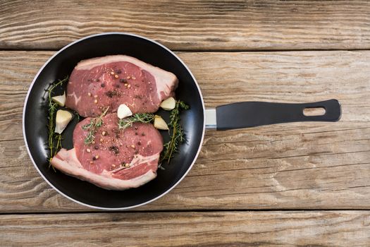 Sirloin chops and herbs in frying pan