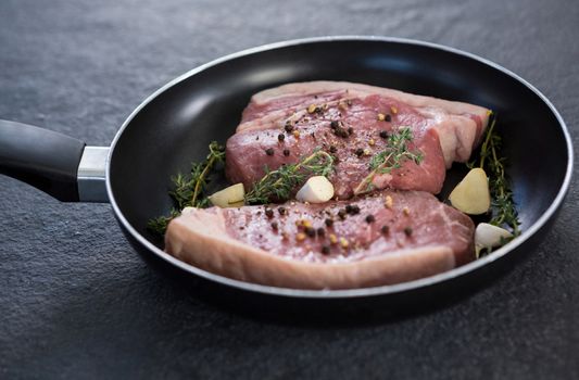 Sirloin chop and herbs in frying pan