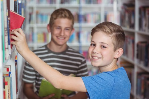 Schoolboys selecting book in library
