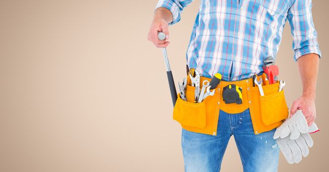 Handyman with tool belt against beige background