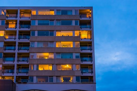 Apartments complex with lighted windows in the evening, modern city architecture in tilburg, The Netherlands
