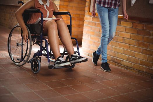 Schoolgirl with her disabled friend in corridor