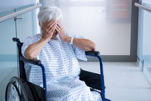 Disabled senior patient on wheelchair in hospital passageway