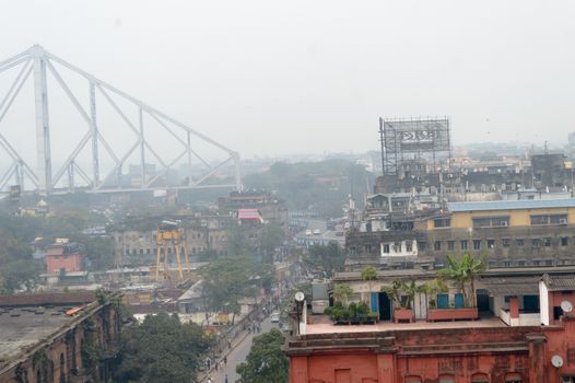 Aerial view rooftop of Calcutta city life of Hooghly riverside Burrabazar area near Howrah Bridge (Rabindra Setu) on a foggy winter evening day. Kolkata West Bengal India, South Asia Pac January 2020