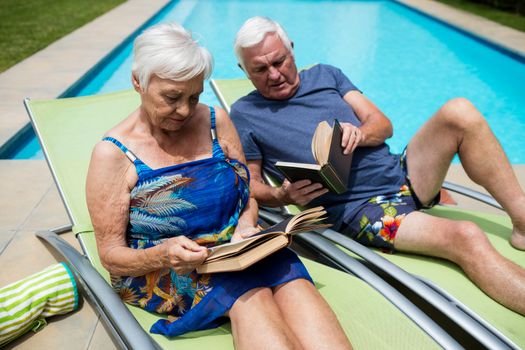 Senior couple reading books on lounge chair