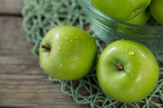 Close-up of green apples with water droplets in bowl