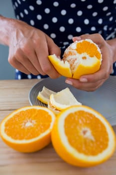 Woman peeling orange