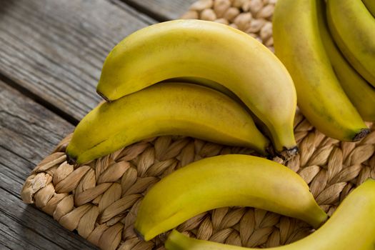 Bananas kept on placemat on wooden table
