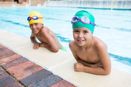 Two kids smiling in the pool