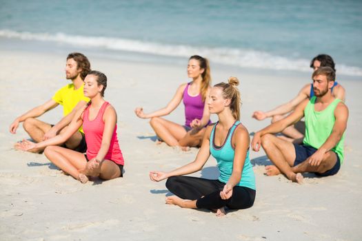Friends meditating at beach
