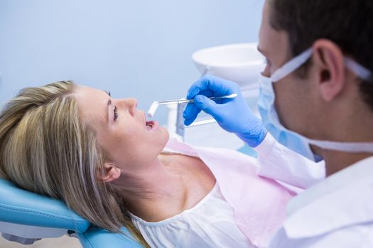 Dentist examining woman at clinic