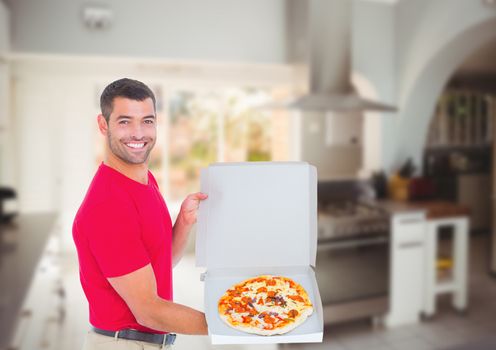 Happy deliveryman showing the pizza in the restaurant kitchen