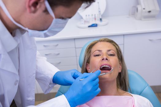 Doctor giving dental treatment to woman at clinic