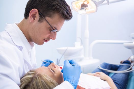 Doctor examining woman with dental equipments