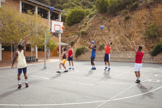 Basketball players practicing in basketball court