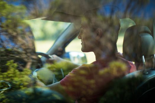 Man seen through car windshield
