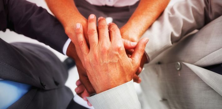 Business people gathering their hands together