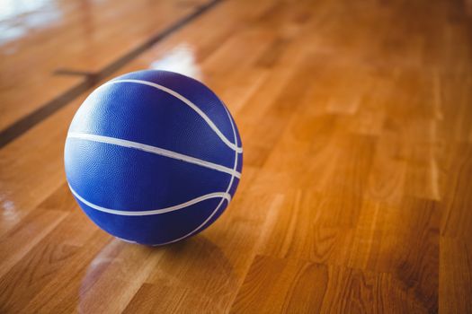 Close up of blue basketball on hardwood floor 