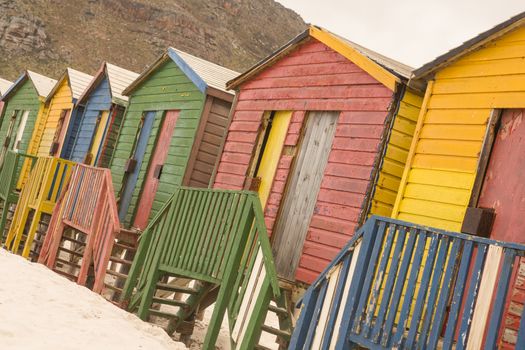 Multi colored wooden huts on sand